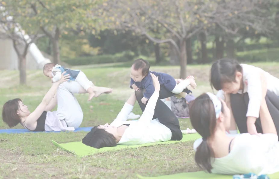 公園でベビーヨガをする女性